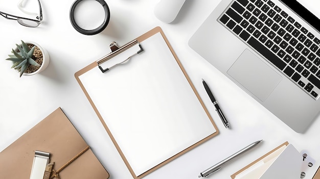 Top view office desk with laptop supplies and clipboard with blank paper Workspace with laptop glasses coffee cup plant pen and notebook