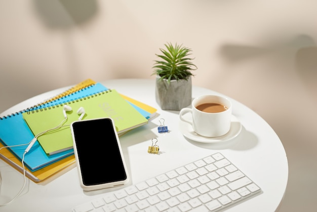 Top view office table desk.Workspace with mobile phone and office supplies on white background.