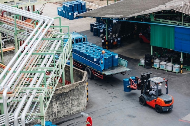 Top view oil barrels forklift truck move for on the transportation truck male worker help