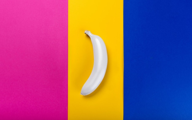 Top view of one whole white colored banana on colorful background