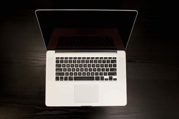 Top view of the open laptop on a black table, space for text