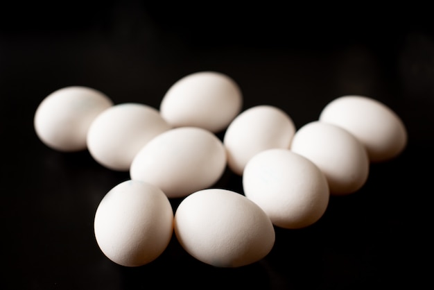 Top view of opened box with eggs on black background.