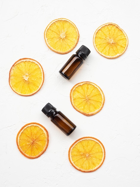 Top view of organic essential oil with slices of dried orange Natural cosmetics product Glass containers with liquid Ecofriendly cosmetics and aromatherapy concept