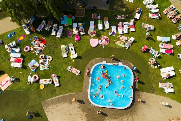 Top view of an outdoor place for people to relax where there is a swimming pool and a lot of sun beds