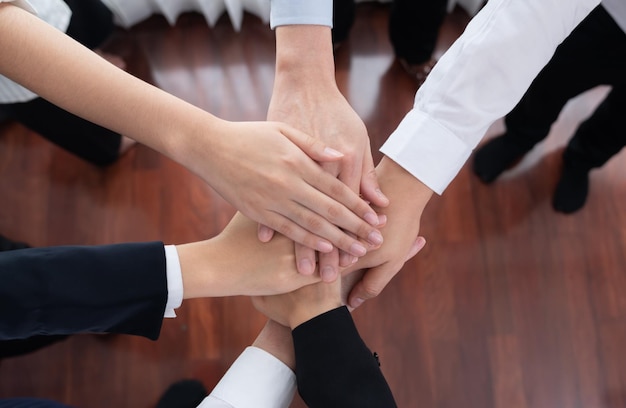 Top view partial hand join stack and form circle as symbol of harmony in office