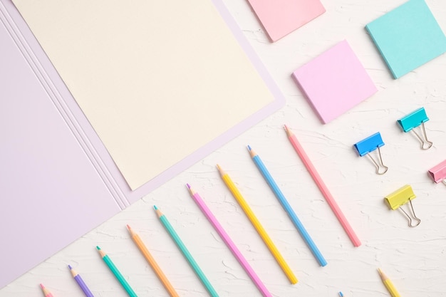 Top view of pastel color pencil and file on white table