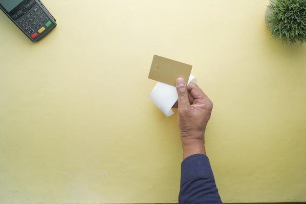 Top view of person hand holding credit card and a sales receipt