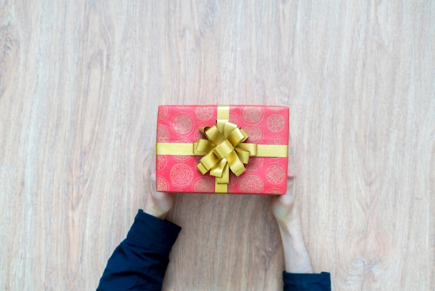 Top view of person's hands hold the holiday present gift box