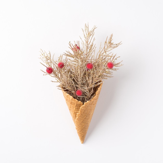 Top view photo of ice cream cone with christmas decorations pine branches and holly berries on isolated white background