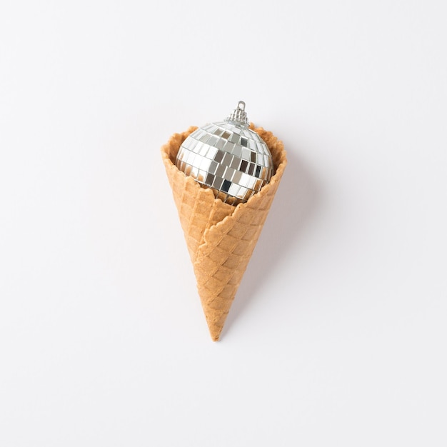 Top view photo of ice cream cone with christmas tree disco ball on isolated white background