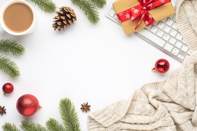 Top view photo of keyboard cup of hot drinking red christmas tree balls pine twigs cone anise sweater and giftbox on isolated white background with empty space in the middle