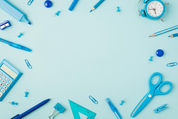 Top view photo of school supplies blue stationery on isolated pastel blue background with copyspace in the middle