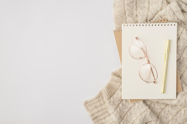 Top view photo of two reminders stylish glasses pen and sweater on isolated white background with copyspace