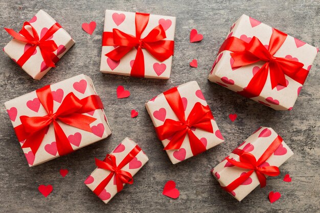 Photo top view photo of valentine day decorations gift box with red ribbon bow on colored background holiday gift boxes with top view