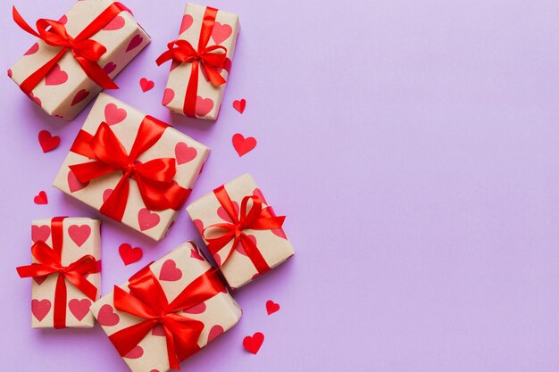 Top view photo of valentine day decorations gift box with red ribbon bow on colored background Holiday gift boxes with top view