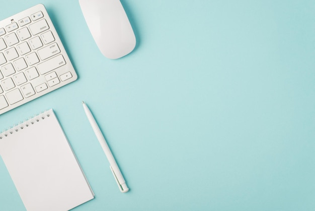 Top view photo of white keyboard mouse organizer and pen on isolated pastel blue background with copyspace