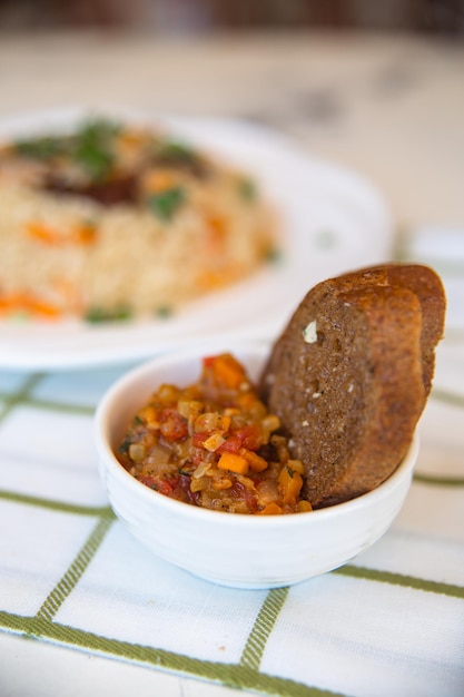 Top view of a piece of bread and a spicy vegetable salad on the table