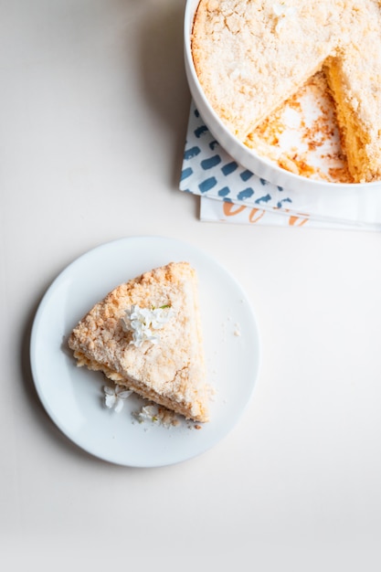 Top view of a piece of cake with curd filling on white background, vertical photo