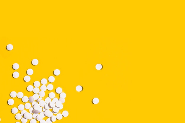 Top view of pills on yellow background