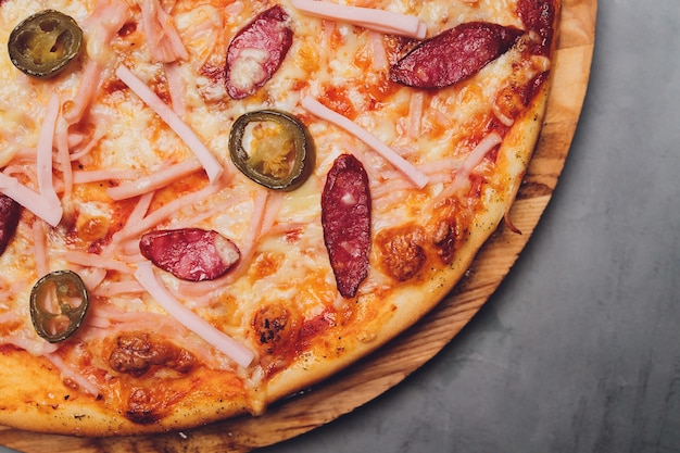 Top view of pizza sicilian with salami, zucchini, jalapeno and bell pepper.