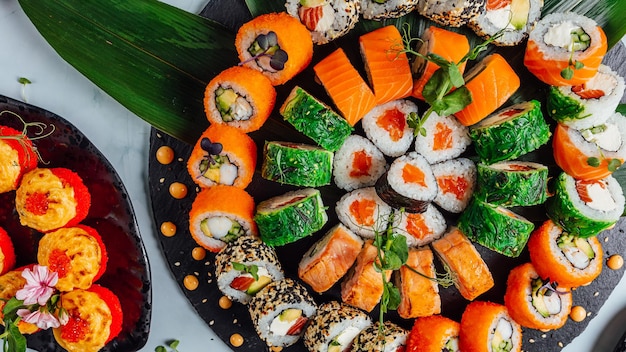 Top view of plates of various delicious fresh sushi rolls