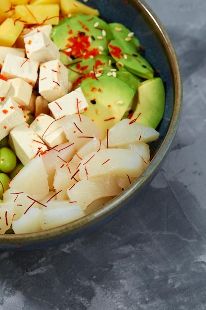 Top view on poke salad with tuna and green vegetable in the bowls on gray background Copy space