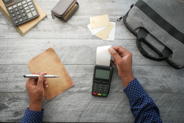 Top view of POS machine and long roll paper on table