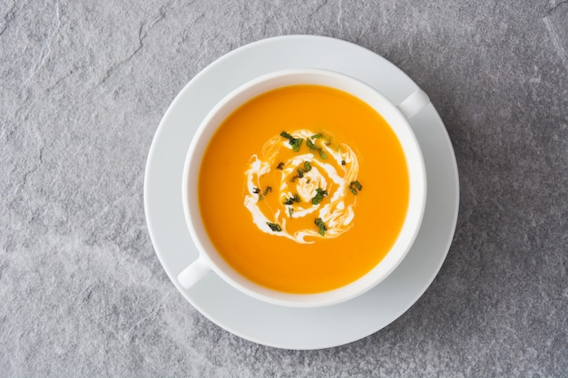 Top view on pumpkin soup in white bowl