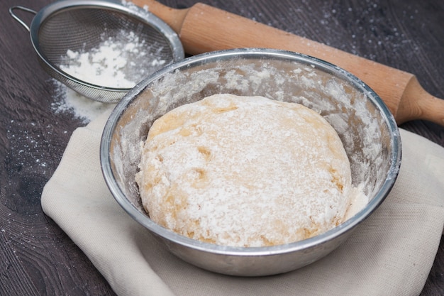 Top view of raw dough for pizza in metal plate