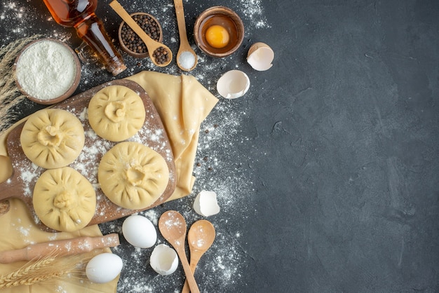 top view raw dumplings over cutting board with flour and eggs