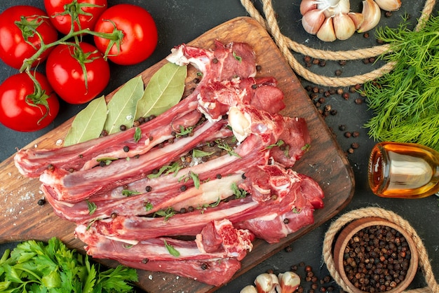 Top view raw meat slices with fresh vegetables and greens on dark background fry butcher food dish meal meat cooking salad