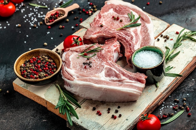 Top view raw pork chop steak on dark background Organic food banner menu recipe place for text