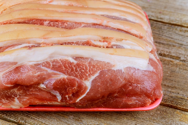 Top view raw pork chop on wooden background.