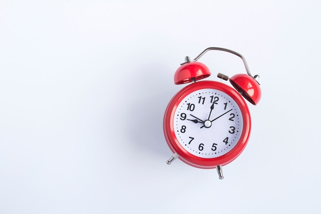 Top view of red alarm clock on the white