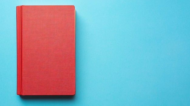 Photo top view of red book on light blue background for creative projects