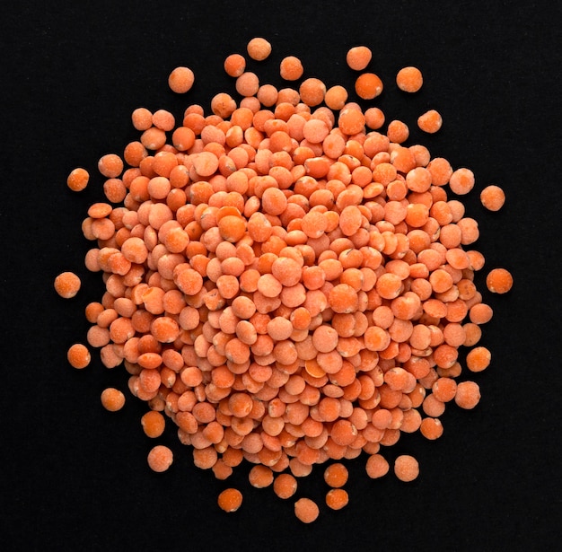 Top view of red lentils on black background