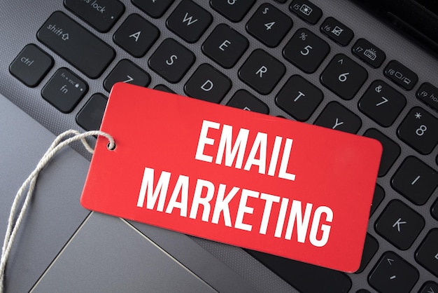 Top view of red paper and the text email marketing on a laptop background