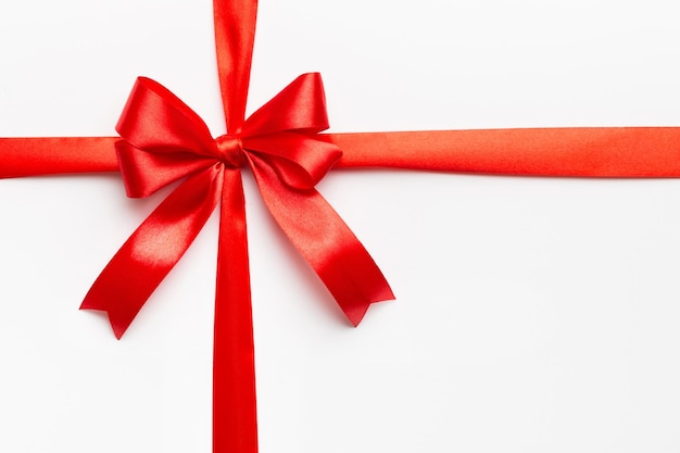 Top view of Red ribbon rolled and red bow isolated on colored background Flat lay with copy space