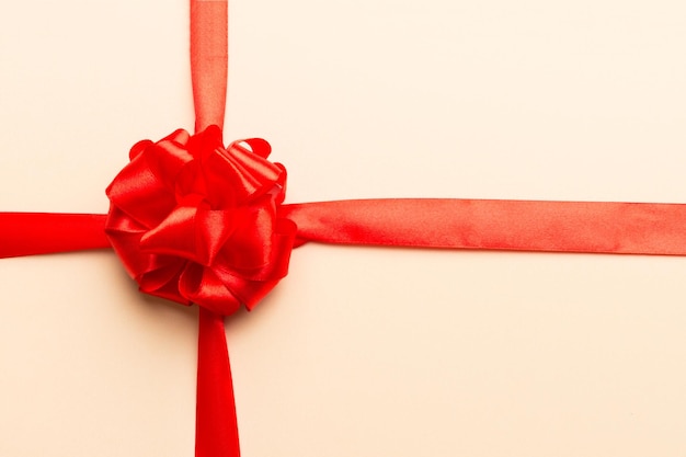 Top view of Red ribbon rolled and red bow isolated on colored background Flat lay with copy space