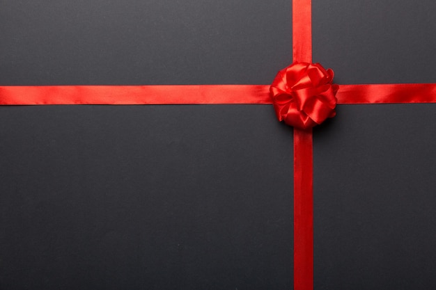 Top view of Red ribbon rolled and red bow isolated on colored background Flat lay with copy space