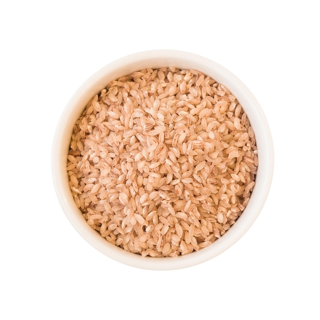 Top view of red rice grains in round ceramic plate. Raw food ingredient isolated on white background