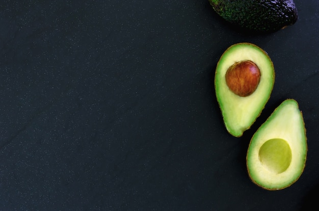 Top view ripe avocado dark tone background.