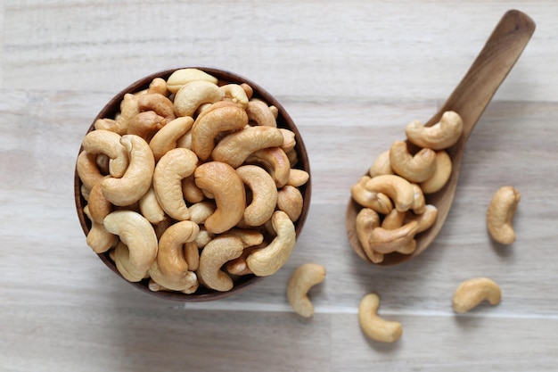 Top view of Roasted cashew nuts in a bowl on wooder background Healthy eating concept