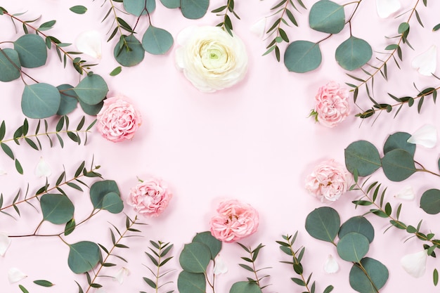 Top view of round flower frame with leaves and copy space isolated on white background, flat lay