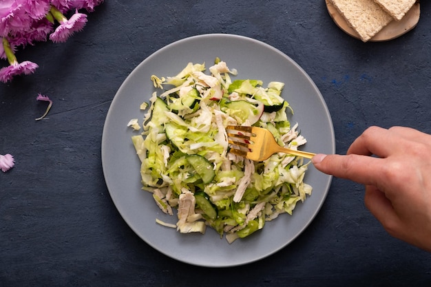 Top view salad of fresh vegetables and meat in a plate on dark stone table The concept of healthy eating