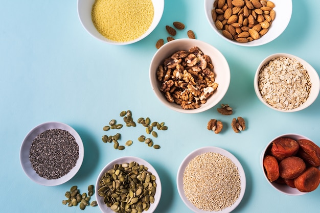 Top view the set of Superfoods in Bowls on blue Background and copy space.