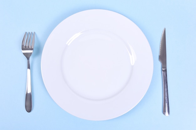 Top view of a set table with a white plate fork and knife