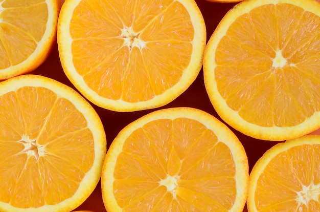 Top view of a several orange fruit slices on bright background 