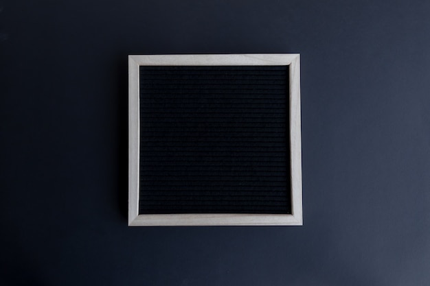 Top view shot of a blank blackboard with a wooden frame on a black background with copy space