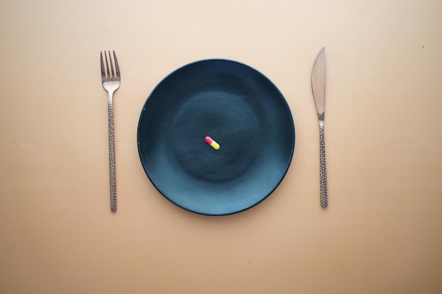 Top view of a single capsule on a plate on table